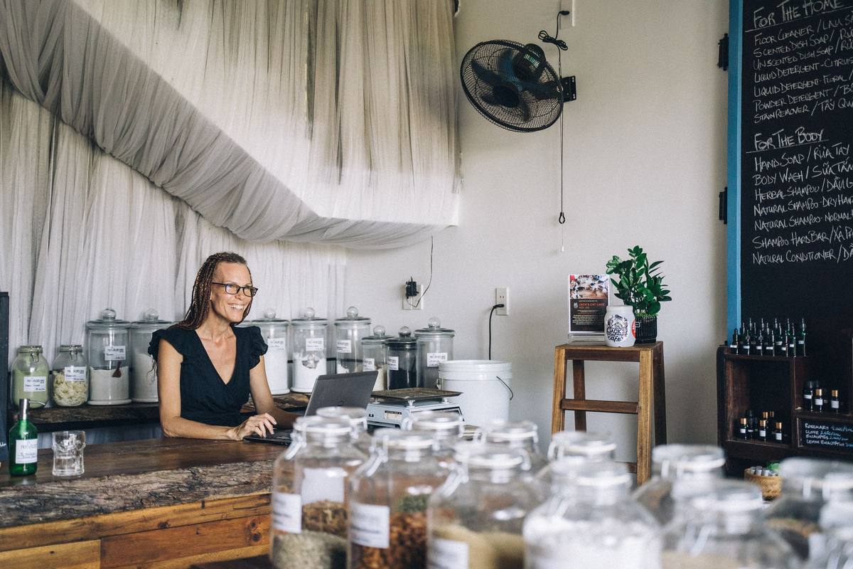 A small business shopkeeper working on a laptop at her counter